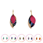 Charger l’image dans la galerie Boucles d’oreilles plume en cuir faites main, mêlant cuir brillant et pailleté pour un éclat moderne. Légères et lumineuses, elles captent la lumière à chaque mouvement. ✨ ambre, noir zèbre et bordeaux