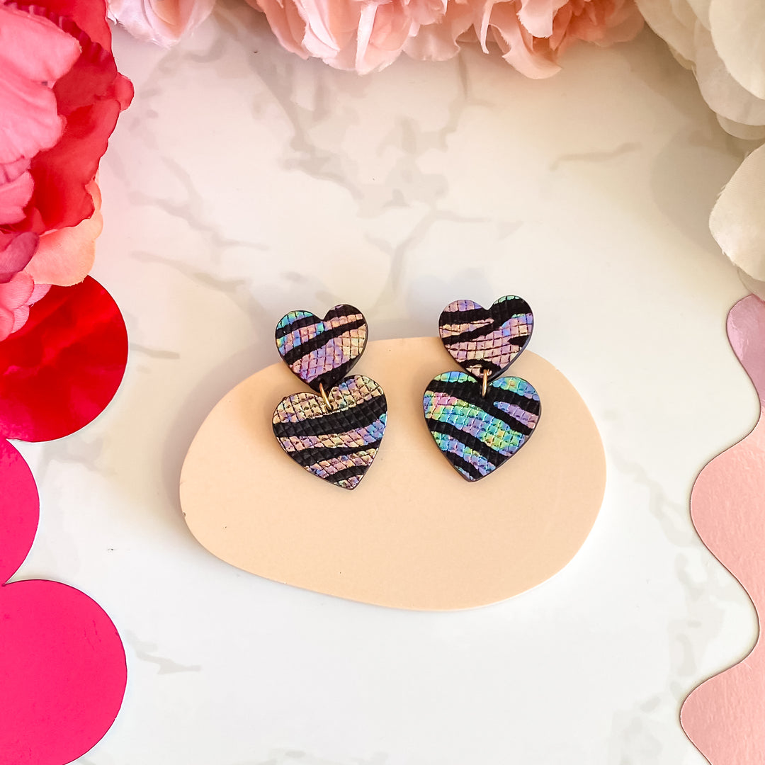 Boucles d’oreilles double cœur en cuir noir zèbre holographique, faites main en France par Manali, bijoux artisanaux légers et vibrants.