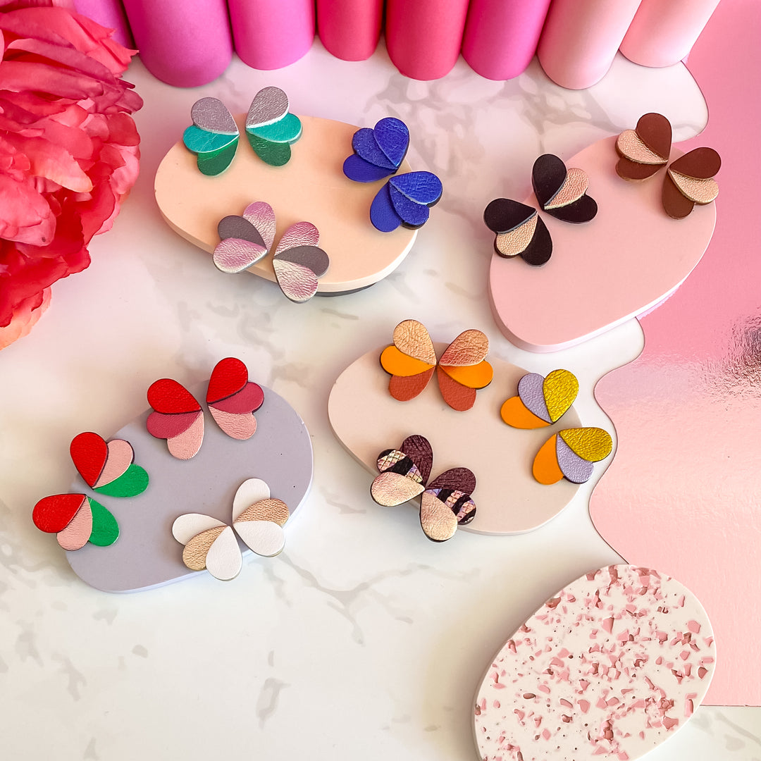 Boucles puces en cuir pailleté doré, multicolore, forme de papillon stylisée.